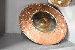 An Arts and crafts copper mirror, of circular form with bevelled mirror plate enclosed by a border
