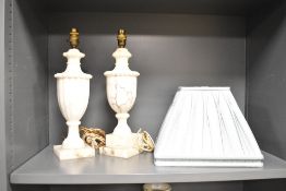 A matched pair of carved and turned stone lamps , believed to be marble and a pair of fabric shades