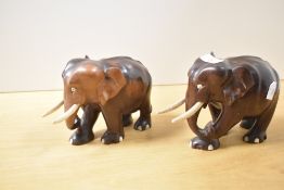 A pair of carved hardwood elephant figures with bone eyes, tusks and foot inserts 12.5cm