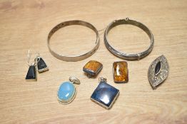 A small collection of silver and white metal jewellery, comprising two bangles, a pair of amber