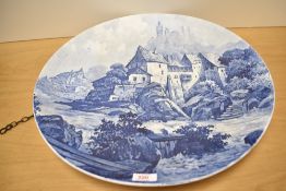 A large decorative charger of circular form having blue and white transfer printed pictorial design,