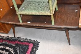 An Ercol dark elm coffee table, of oblong form with spindle under-tier 36cm x 103cm x 41cm