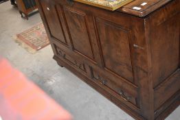 A reproduction TV cabinet with rise and fall mechanism, in the form of three panel mule chest