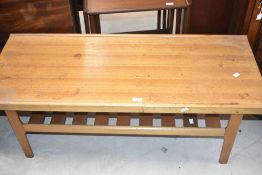 A 1960's/70's teak coffee table, of oblong form with slatted under tier, 45cm x 111cm x 45cm some