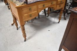 A Victorian golden oak kneehole desk having skiver top, gothic style handles and turned legs,