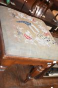A Victorian mahogany stool having peacock decoration to tapestry seat