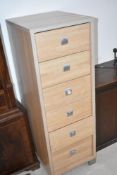 A set of laminate narrow drawers and a dark stained cabinet