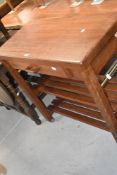 A modern mahogany trolley table with single drawer, slatted under tiers and casters 80cm x 80cm x