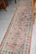 A machine made Persian design runner with terracotta field 232cm x 70cm
