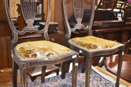 A pair of Edwardian mahogany salon chairs having inlaid decoration and overstuffed seats