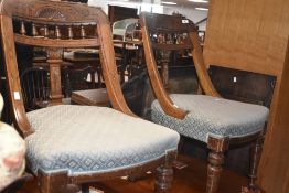A pair of Victorian oak framed art spindle back chairs having overstuffed seats
