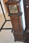 An early 20th Century oak cased Grandmother style long case clock having brass Roman numeral dial,