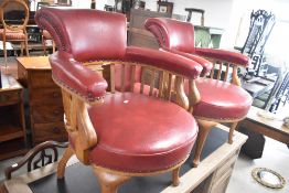 A pair of late 19th or early 20th Century golden oak low seat armchairs , having red leather