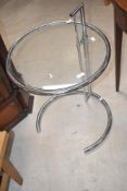 A chrome plated metal and glass occasional table, of circular for with tubular supports 60cm