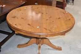 A vintage yellow pine circular extending dining table
