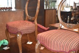 A pair of Victorian salon chairs having later stripe upholstery
