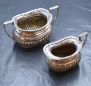 A Victorian silver sugar and cream, of bulbous form having gadrooned rims, angular handles and