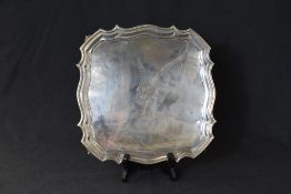 A George V silver salver, of square form having a Chippendale rim with 'BMJ' monogram to the centre,