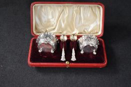 A cased pair of Victorian silver salts, having crimped rims with embossed floral scroll decoration