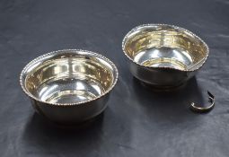 A George V silver sugar and cream, of squat circular form having egg and dart style rims, raised