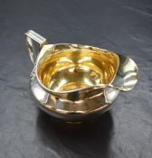 A George III silver sauce boat, of squat bulbous form having a moulded rim, a broad spout opposed by