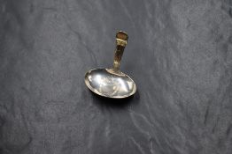 A George III silver caddy spoon, having a vacant shield engraved to the bowl with decorative