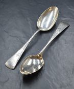 A pair of American sterling serving spoons, having decorative engraving to the terminals with '