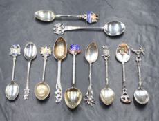 A collection of eleven silver and white metal teaspoons, including souvenir spoons, a