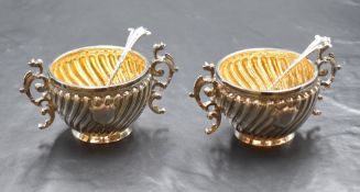 A pair of Victorian silver salts, of traditional form having gadrooned bodies with vacant shield