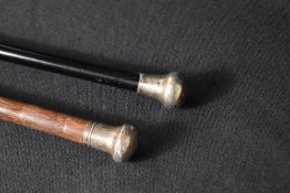 Two George V silver mounted walking sticks, the plain pommels to the bamboo and ebonised canes,