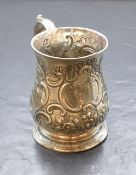 A George II silver tankard, of traditional bulbous form, having a scroll handle, embossed scroll and