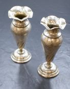 A pair of Eastern white metal vases, of fluted form having lobed rims and floral engraving, with