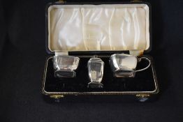 A cased Elizabeth II silver three piece condiment set, comprising a salt, mustard and pepperette, of