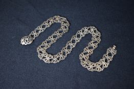 A Chinese Straits Peranakan white metal belt, the links having an interlocking two headed serpent
