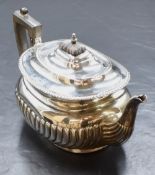 An Edwardian silver teapot, of oval form having a gadrooned rim and half gadrooned body, marks for