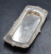 A late George III silver pin tray, of rectangular form having gadrooned and scroll rim and a