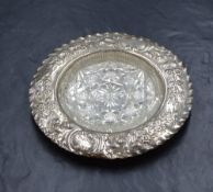 A Victorian silver wine bottle coaster, having a crimped rim and floral scroll engraving with a