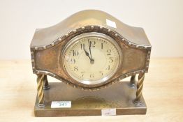 A vintage metallic mantel clock, complete with key.