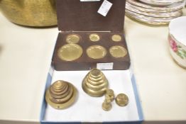 A Set of brass weights in wooden case, sold alongside a group of stacking weights and a half ounce