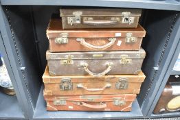 A set of 5 early 20th century leather suit cases, largest w56cm