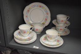 A Susie Cooper bone china tea service, having gilt handles and decorated with floral patterns on a