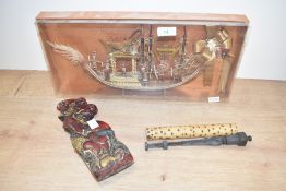 A relief diorama depicting an ornate boat with figures, L42cm, sold together with 2 cases holding