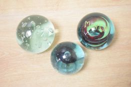 A glass paperweight having controlled bubble decoration, h7cm, sold together with 2 others