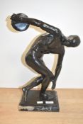 A patinated metal disc thrower sculpture modelled on the original Greek sculpture 'Discobolus',