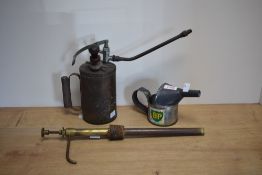 Two vintage oil cans and a oil can pump