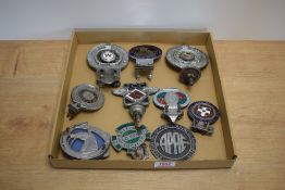 An Assortment of 10 vintage bumper and car badges including Westmorland automobile club,