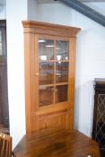 A pine corner display having cupboard under
