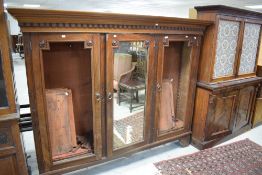 A late Victorian mahogany bookcase, having a swept and dentil moulded cornice over three panelled