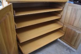 A modern golden oak cupboard having internal slide out shelves, dimensions approx. W143 H122 D59cm