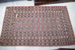 A North West Persian Bokhara type rug, with tasselled ends 160cm x 95cm